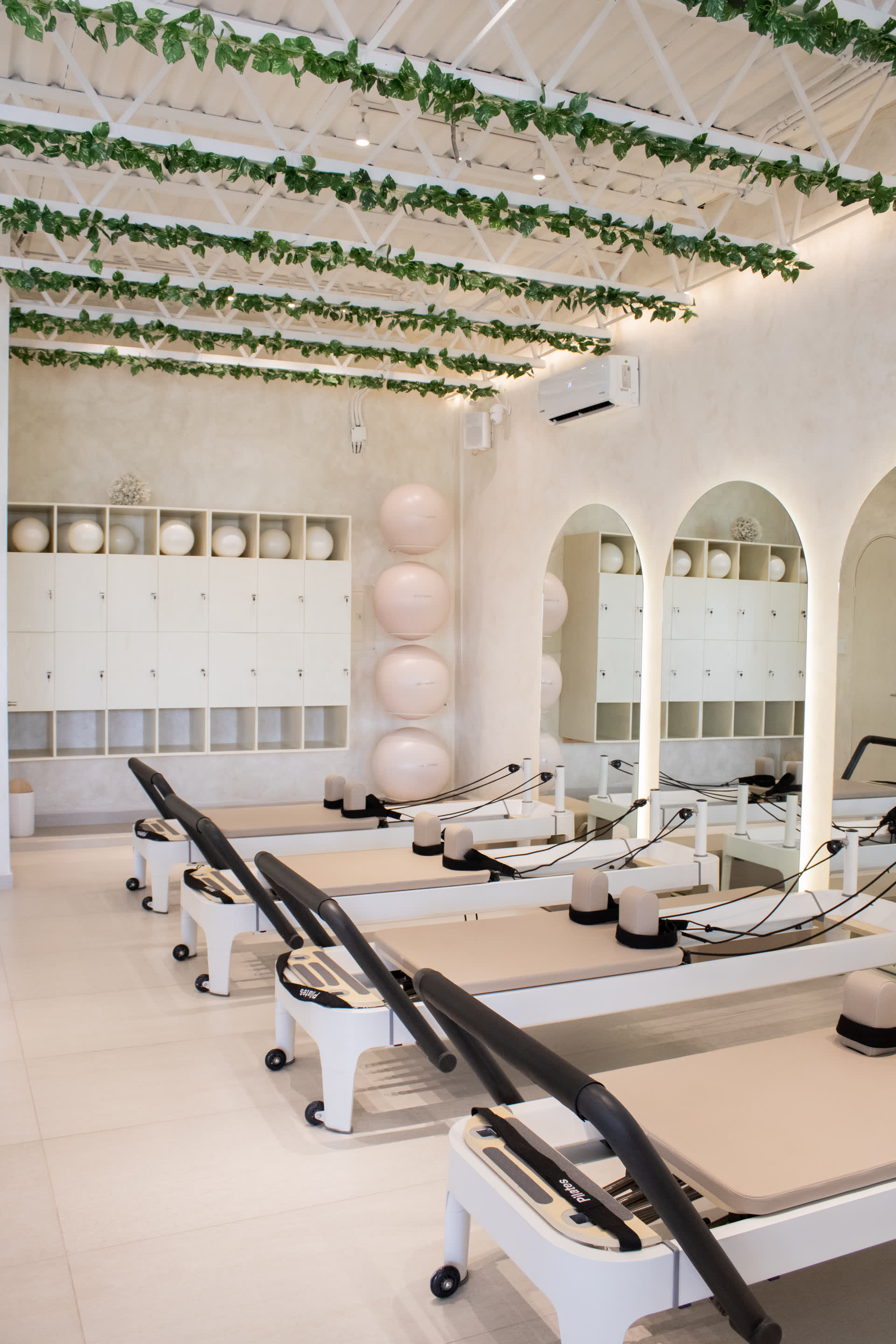 Sala de Calzada con reformers blancos y plantas colgantes