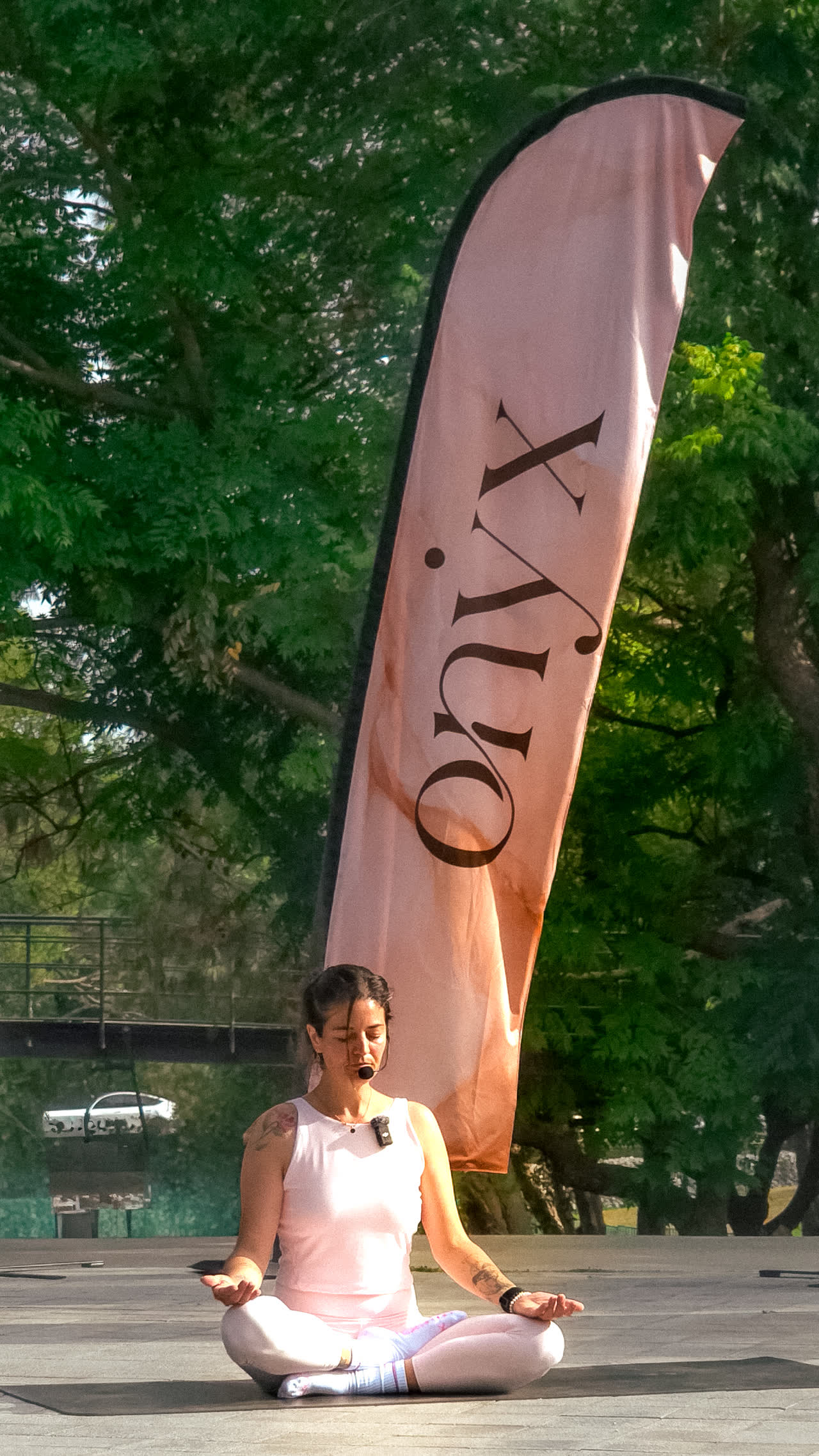 Coach de Onyx guiando una meditación al aire libre junto a la bandera del estudio