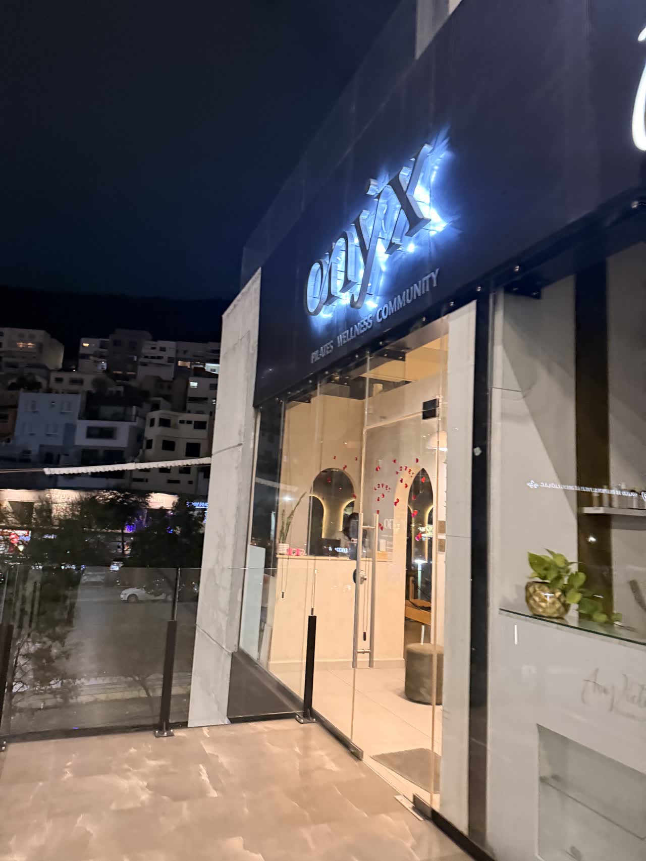 Fachada de Onyx San Jerónimo de noche con el letrero encendido
